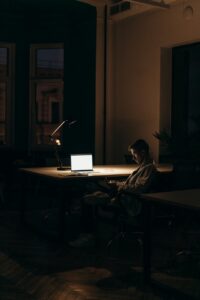 man in black and white stripe dress shirt sitting on chair in front of macbook