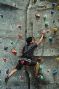 flexible man practicing climbing on wall